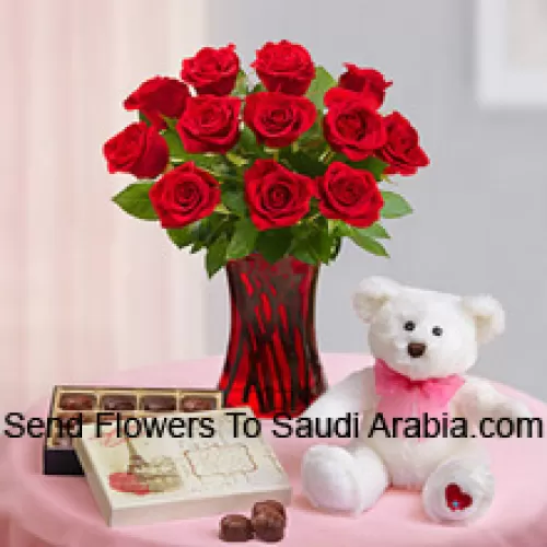 12 Red Roses With Some Ferns In A Glass Vase, A Cute 12 Inches Tall White Teddy Bear And An Imported Box Of Chocolates