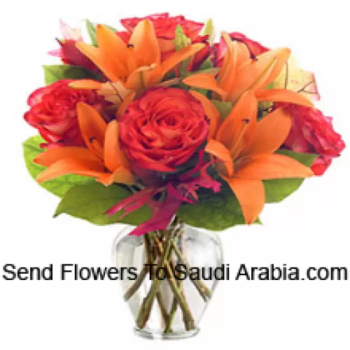 Lys orange et roses orange avec des garnitures saisonnières disposés magnifiquement dans un vase en verre
