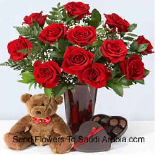 12 Red Roses With Some Ferns In A Vase, Cute Brown 10 Inches Teddy Bear And A Heart Shaped Chocolate Box.
